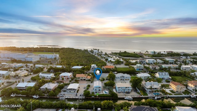 aerial view at dusk featuring a water view