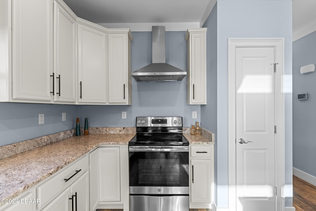 kitchen featuring hardwood / wood-style floors, wall chimney exhaust hood, stainless steel range with electric stovetop, and light stone countertops