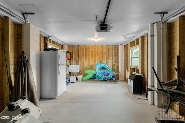 garage featuring a garage door opener and white fridge