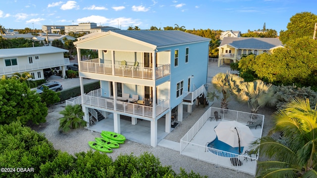 rear view of property with a patio and a balcony