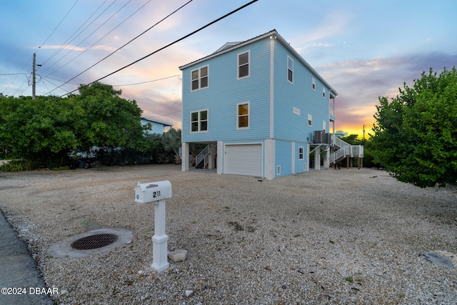 view of front facade featuring a garage and central AC unit