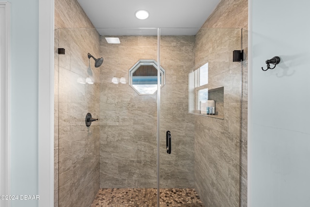 bathroom featuring a shower with shower door