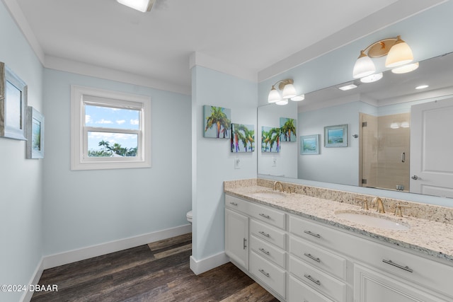 bathroom with ornamental molding, hardwood / wood-style floors, an enclosed shower, and vanity