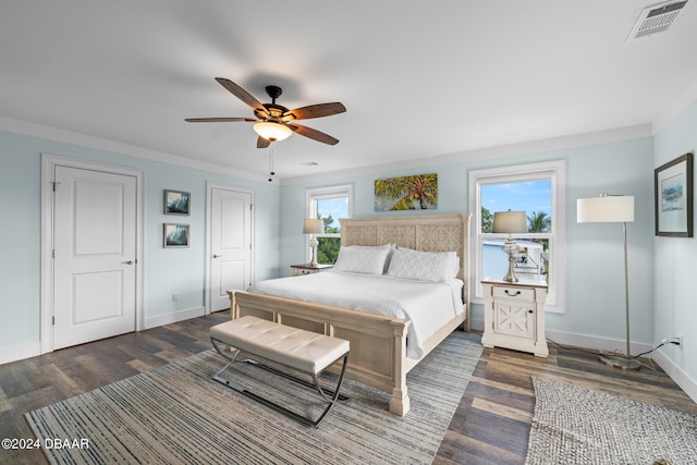 bedroom with ceiling fan, crown molding, and dark hardwood / wood-style flooring