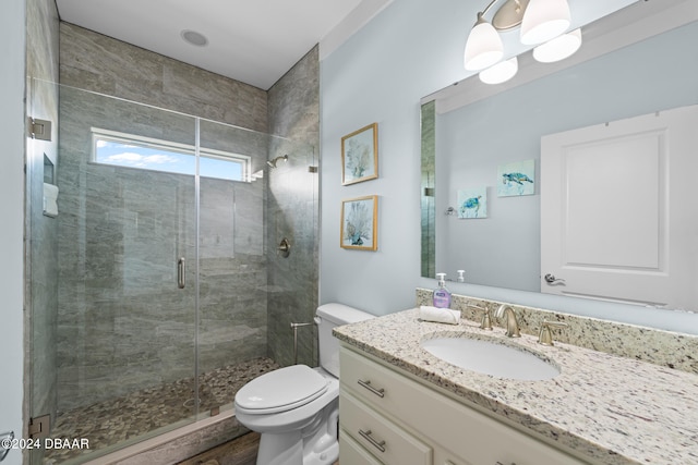 bathroom with hardwood / wood-style floors, a shower with door, vanity, and toilet