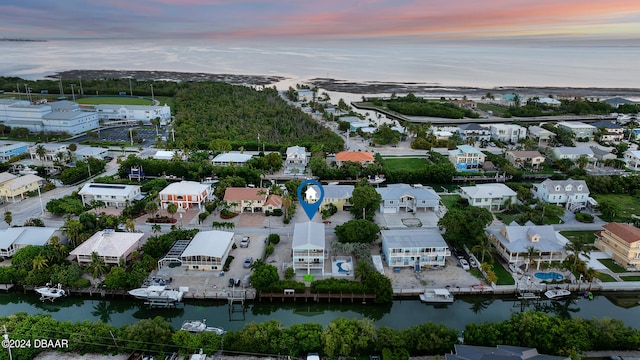 aerial view at dusk featuring a water view