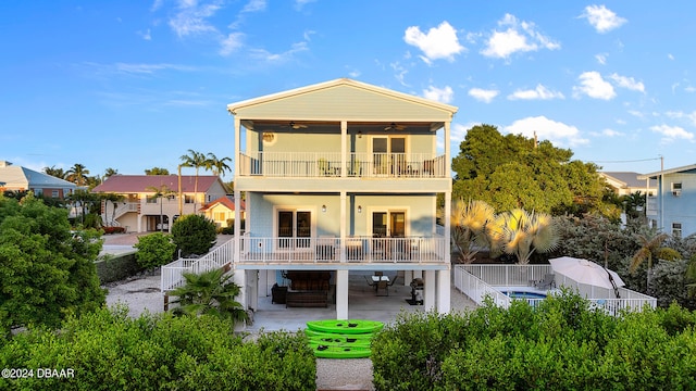 back of property featuring ceiling fan, a patio, and a balcony