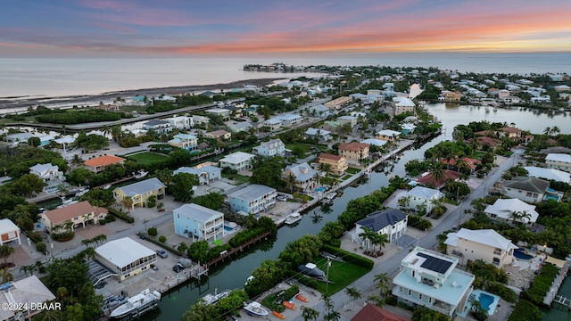 aerial view at dusk featuring a water view