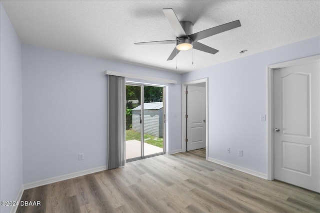 spare room featuring baseboards, a textured ceiling, and wood finished floors