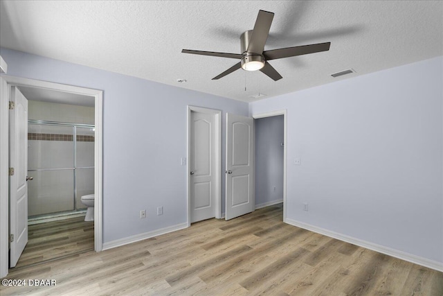 unfurnished bedroom featuring light wood finished floors, visible vents, a textured ceiling, and baseboards