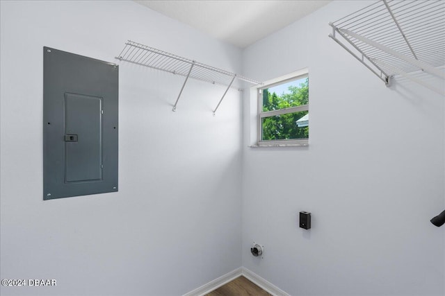 laundry room with wood finished floors, baseboards, hookup for an electric dryer, laundry area, and electric panel