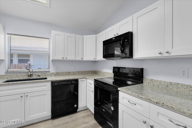 kitchen with black appliances, light wood-style flooring, white cabinets, a textured ceiling, and a sink