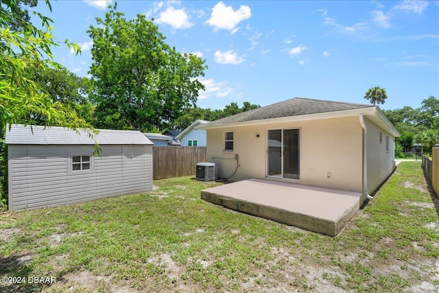 back of house with a shed, a yard, a fenced backyard, a patio area, and an outbuilding