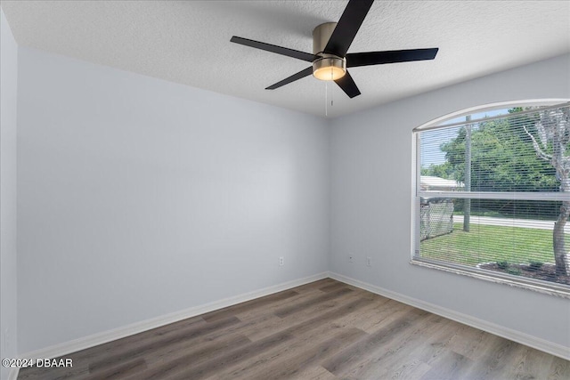 empty room with ceiling fan, baseboards, a textured ceiling, and wood finished floors