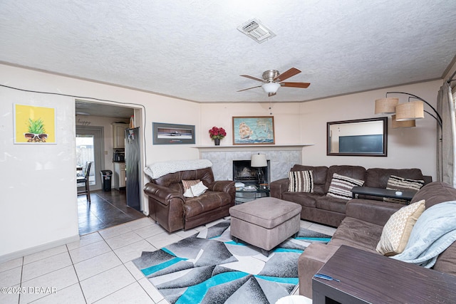 1412 Sunland Rd, Daytona Beach, FL 32114 - living area with visible vents, ceiling fan, a textured ceiling, and light tile patterned flooring