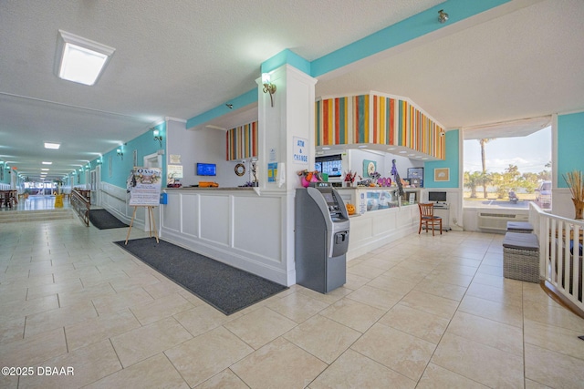 kitchen featuring light tile patterned floors, white cabinets, and a textured ceiling