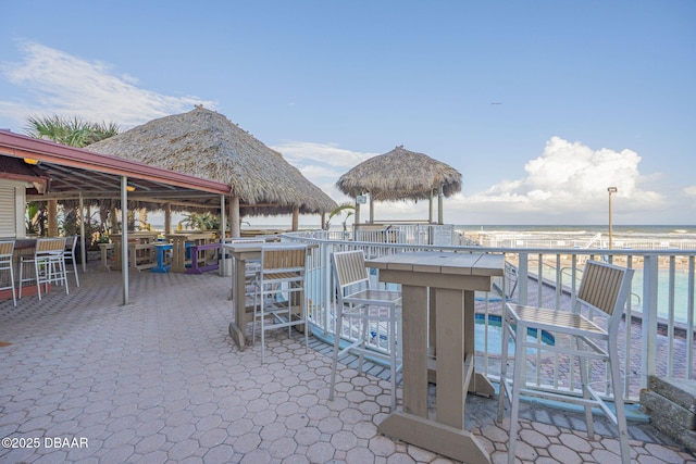 view of patio / terrace with a water view, a gazebo, and exterior bar