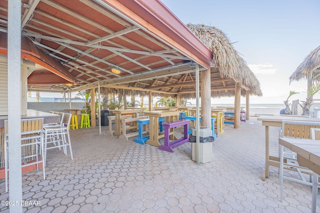 view of patio featuring a water view, exterior bar, and a gazebo