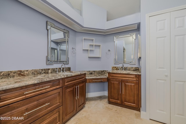 full bath with a closet, vanity, and baseboards