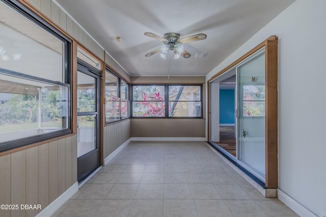 unfurnished sunroom with visible vents and ceiling fan