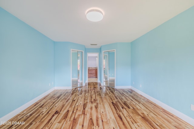 empty room featuring baseboards and wood finished floors