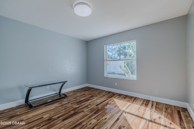 empty room featuring wood finished floors and baseboards