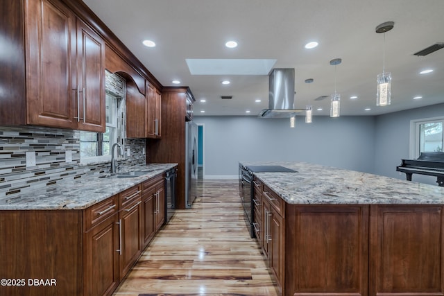 kitchen featuring visible vents, black appliances, a sink, island exhaust hood, and a skylight