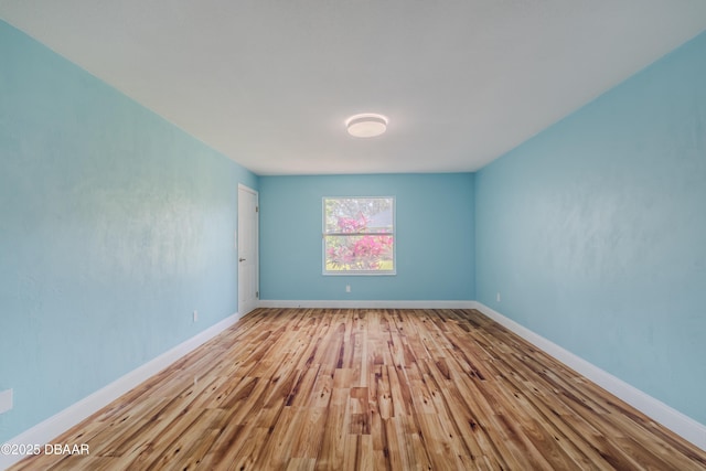 unfurnished room featuring baseboards and wood finished floors