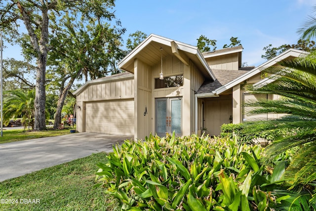 view of front of property featuring a garage, cooling unit, and a front yard