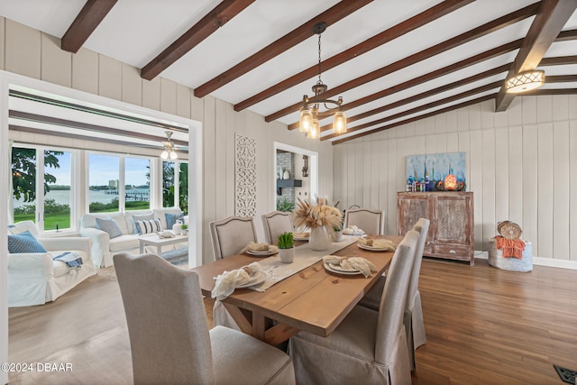 dining room with lofted ceiling with beams, an inviting chandelier, and dark hardwood / wood-style floors