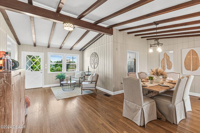 dining area featuring lofted ceiling with beams and dark wood-type flooring