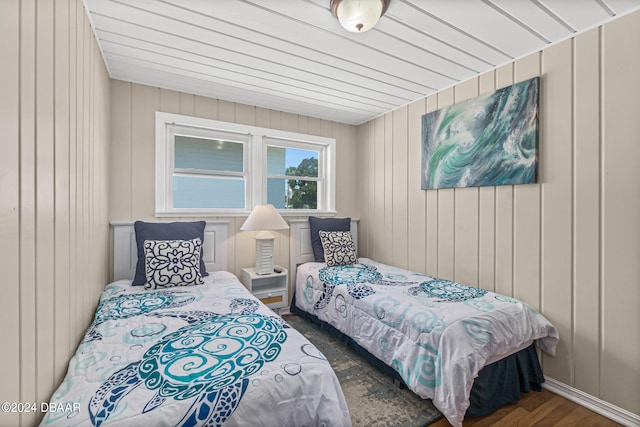 bedroom featuring wood walls and dark hardwood / wood-style floors