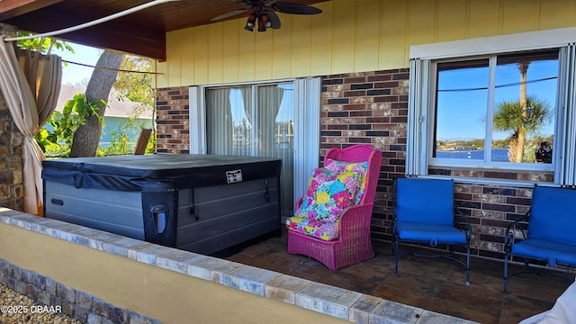 view of patio with ceiling fan and a hot tub