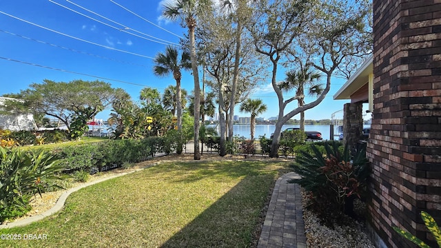 view of yard with a water view and fence