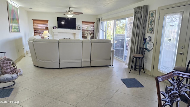 living room featuring light tile patterned flooring, ceiling fan, and baseboards