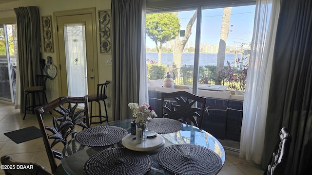 dining space featuring tile patterned flooring and a water view