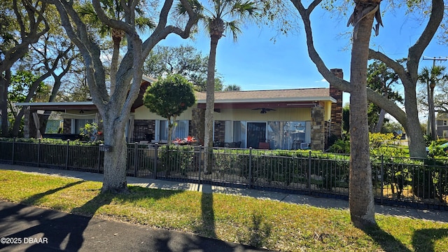 view of front facade with stone siding and a fenced front yard