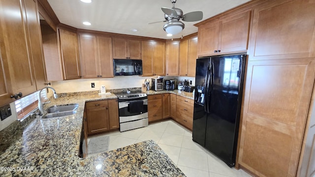 kitchen featuring light tile patterned floors, brown cabinetry, stone counters, a sink, and black appliances