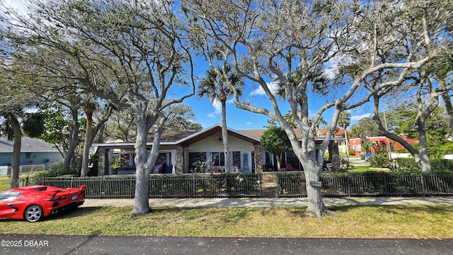 view of front facade with stone siding and a fenced front yard