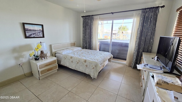 bedroom featuring light tile patterned floors, baseboards, and access to exterior