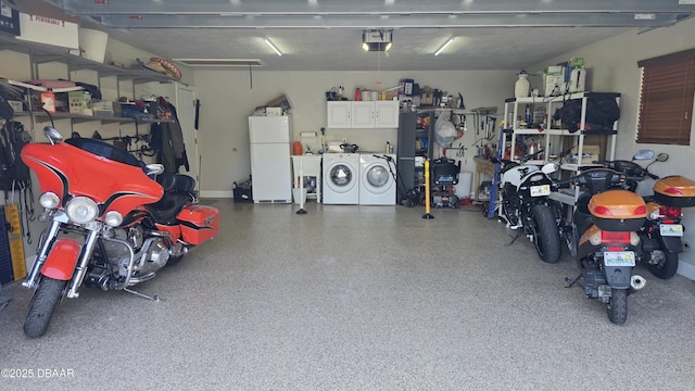 garage featuring a garage door opener, washing machine and dryer, and freestanding refrigerator