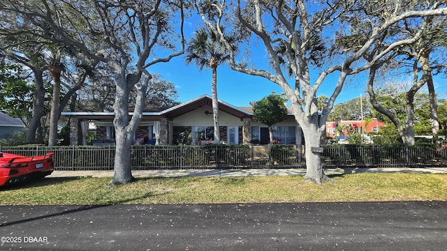 view of front of property featuring a fenced front yard and stone siding