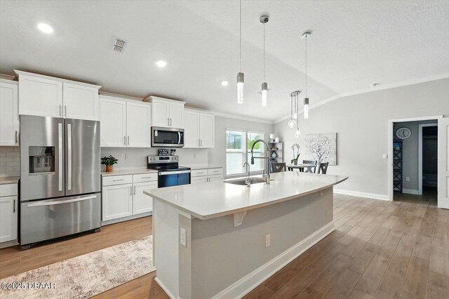 52 Lumber Jack Trl, Palm Coast, FL 32137 - kitchen featuring stainless steel appliances, a sink, lofted ceiling, crown molding, and light countertops
