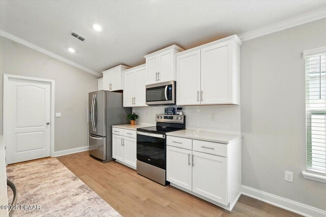 52 Lumber Jack Trl, Palm Coast, FL 32137 - kitchen featuring appliances with stainless steel finishes, crown molding, light wood-style floors, light countertops, and recessed lighting