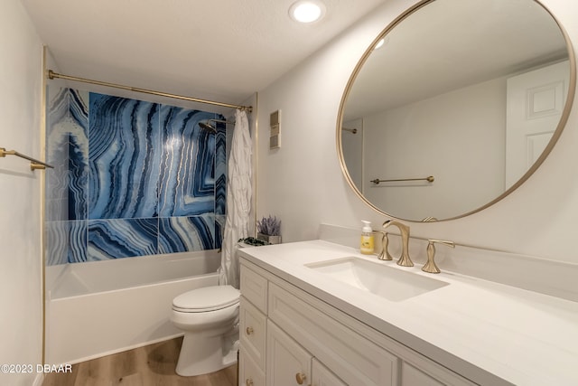 full bathroom with hardwood / wood-style floors, shower / bath combo with shower curtain, vanity, and toilet