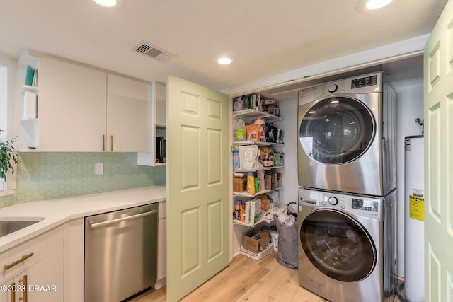 laundry room with water heater, stacked washer and clothes dryer, and light hardwood / wood-style floors