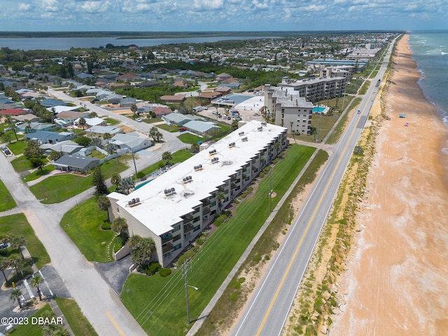 drone / aerial view featuring a beach view and a water view