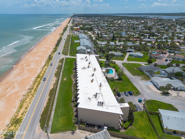 drone / aerial view featuring a beach view and a water view