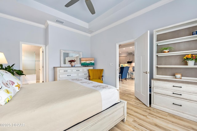 bedroom featuring connected bathroom, ornamental molding, ceiling fan, a raised ceiling, and light hardwood / wood-style flooring