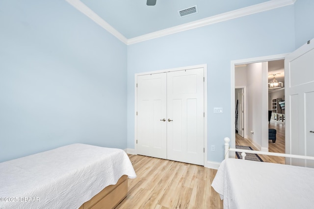 bedroom with ornamental molding, a closet, ceiling fan, and light wood-type flooring